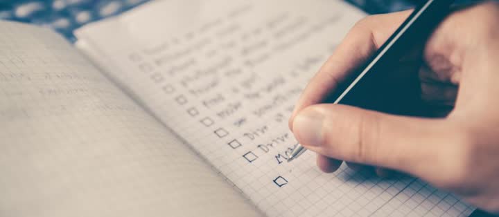 Hand ticking items off a checklist