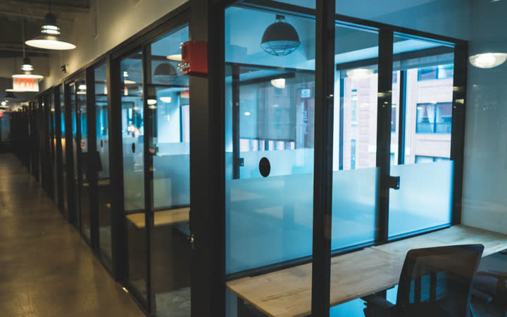 Modern office corridor with glass-walled meeting rooms